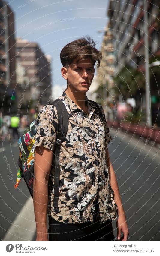 Porträt von authentischen jungen Mann mit Skateboard in der Mitte der Straße. Typ Skateboarderin urban Model retro Einstellung Aussehen Starrer Blick Gesicht