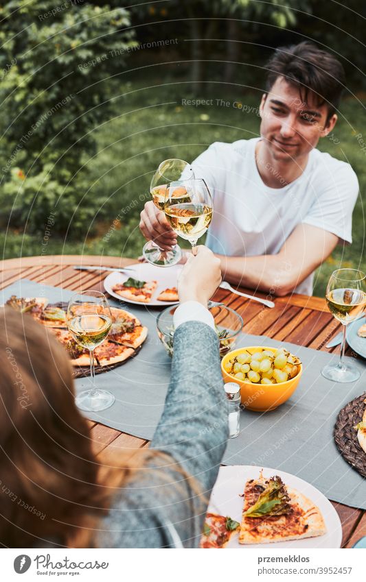 Freunde machen Toast während Sommer-Picknick im Freien Abendessen in einem Haus Garten Hinterhof Getränk Feier Speise trinken Essen Familie Festessen