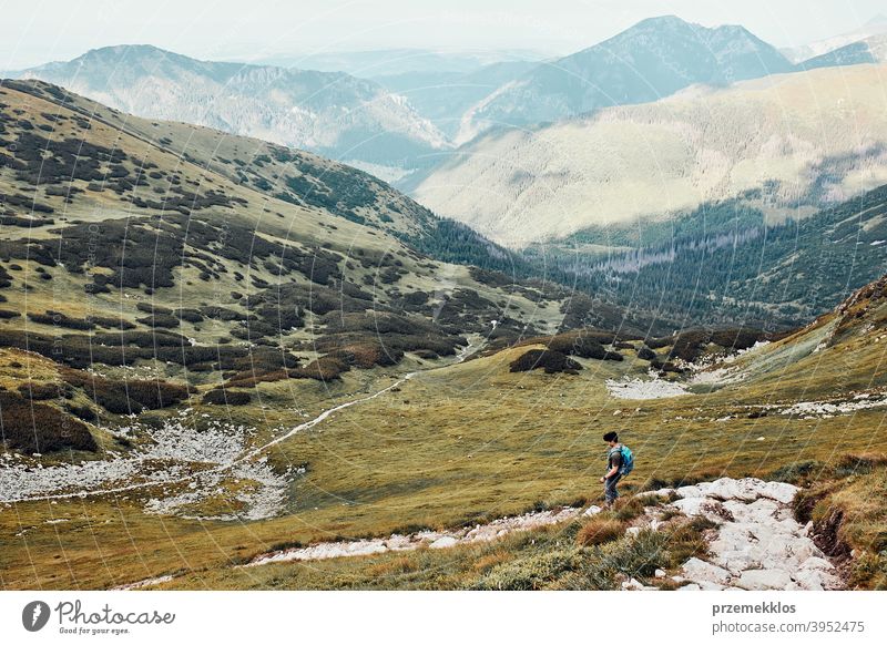 Junger Mann mit Rucksack Wandern in einem Gebirge, aktiv verbringen Sommerurlaub Aktivität Abenteuer Freiheit Gesundheit Freude Freizeit Natur Park Erholung