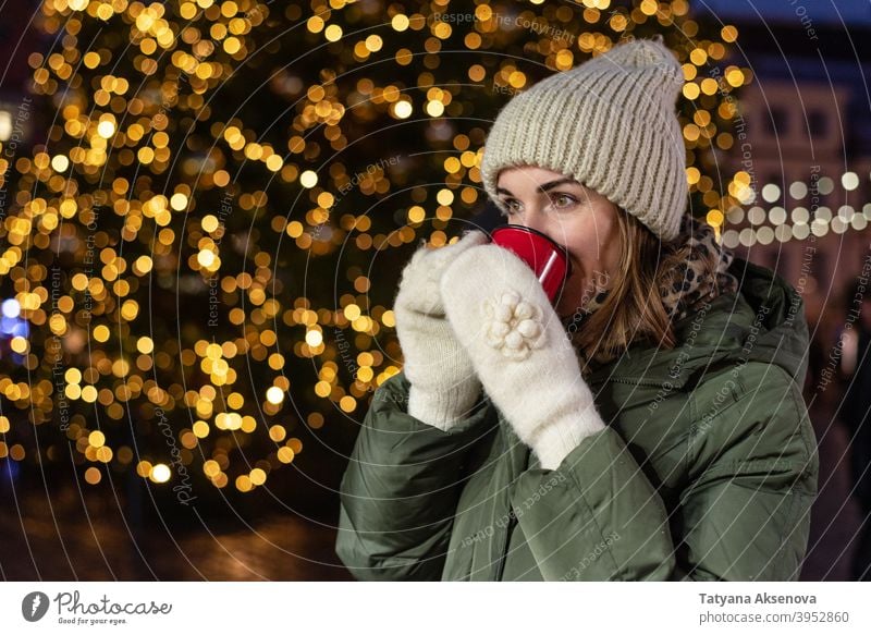 Trinkende Frau auf dem Weihnachtsmarkt Weihnachten Tasse trinken Markt Feiertag Glühwein Heißgetränk Winter im Freien Person Erwachsener Dezember Licht heiter