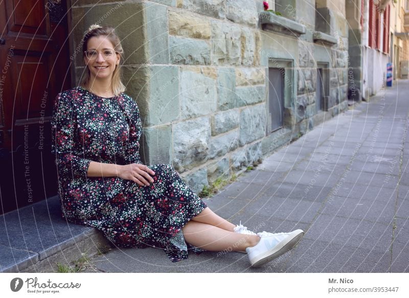 junge Frau sitzt vor der Haustüre und wartet sitzen Tür warten Fassade Gebäude Altstadt Eingangstür Hauseingang Sommerkleid Bürgersteig Verabredung Mode Porträt