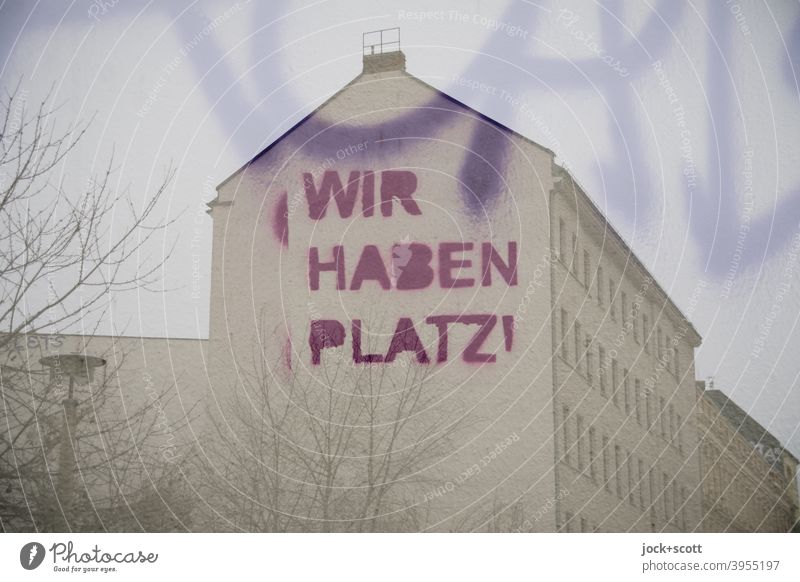 WIR HABEN PLATZ in der Stadt Brandmauer Architektur Stadthaus Fassade Straßenkunst Doppelbelichtung Großbuchstabe Wort Kreativität Äste Winter Subkultur