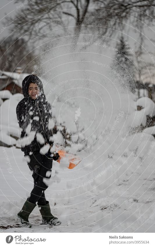 Menschen freuen sich immer über den ersten Schnee / den größten Schneesturm seit ein paar Jahren Junge Reinigungsschnee genießend Winter kalt Außenaufnahme