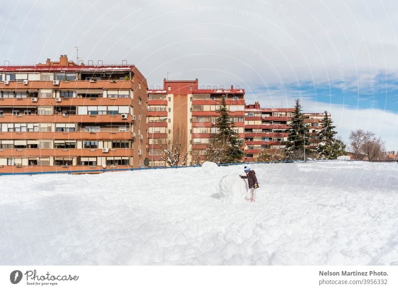 Kleines Mädchen spielt mit einem großen Schneeball in der Nachbarschaft. Gesicht Dezember Schneefall hübsch Baby Nizza reisen 1 Winter Freude Hut Saison