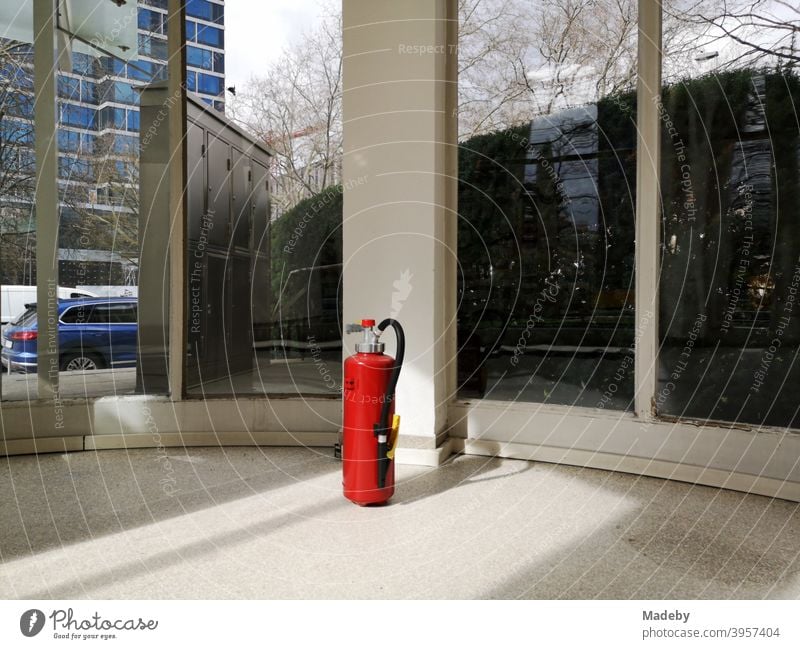 Roter Feuerlöscher im Foyer eines denkmalgeschützten Bürogebäude der Fünfzigerjahre im Westend von Frankfurt am Main in Hessen Knallrot Sicherheit Brandschutz