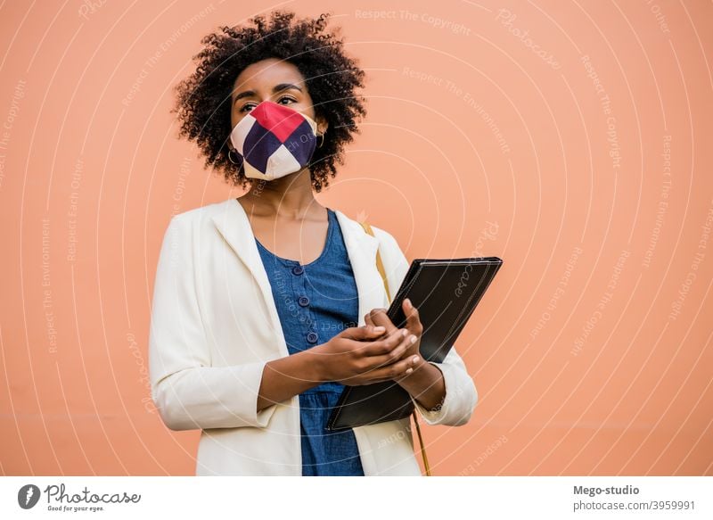 Afro-Geschäftsfrau steht im Freien auf der Straße. Afro-Look Business Frau Schutzmaske Beruf behüten trinken Pandemie Geschäftsmann Konzept Getränk korporativ