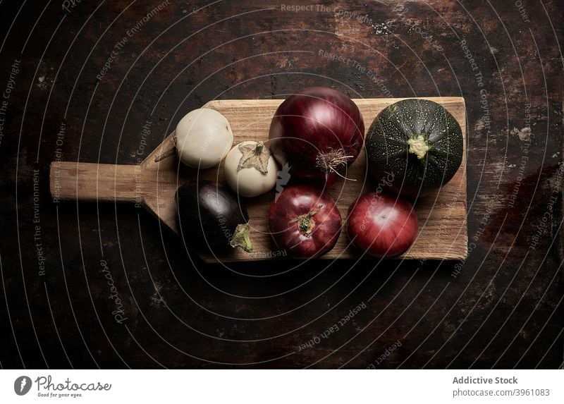 Draufsicht auf sortiertes Gemüse auf abgenutztem braunem Hintergrund Lebensmittel Tomaten Salatgurke Aubergine Pomodoro Vegetarier roh Gesundheit rote Zwiebel