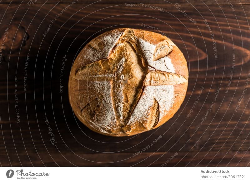 Runder Laib frisch gebackenes Brot Brotlaib rund Knusprig Lebensmittel Bäckerei ganz Kunstgewerbler Kruste lecker hölzern Tisch Ernährung Tradition Mahlzeit