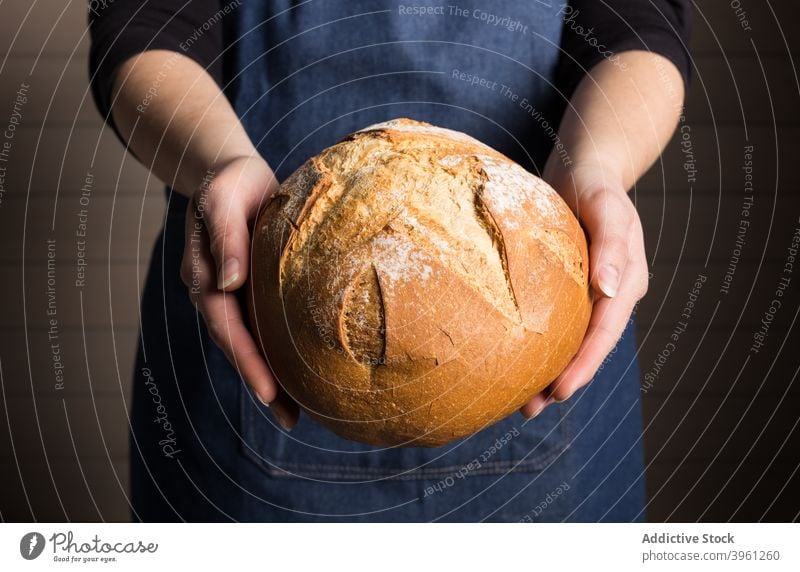 Bäcker mit frischem Brotlaib manifestieren Korn gebacken Lebensmittel Bäckerei Küche kulinarisch Koch Küchenchef Mahlzeit zeigen ganz Kruste Knusprig aromatisch