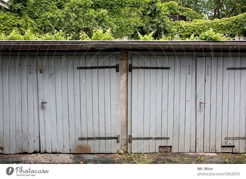 Schuppen Tor Garage Garagentor geschlossen Tür grau trist Hinterhof Gebäude Holztor ruhig Efeu geheimnisvoll Nostalgie verwittert dach garagentor freihalten