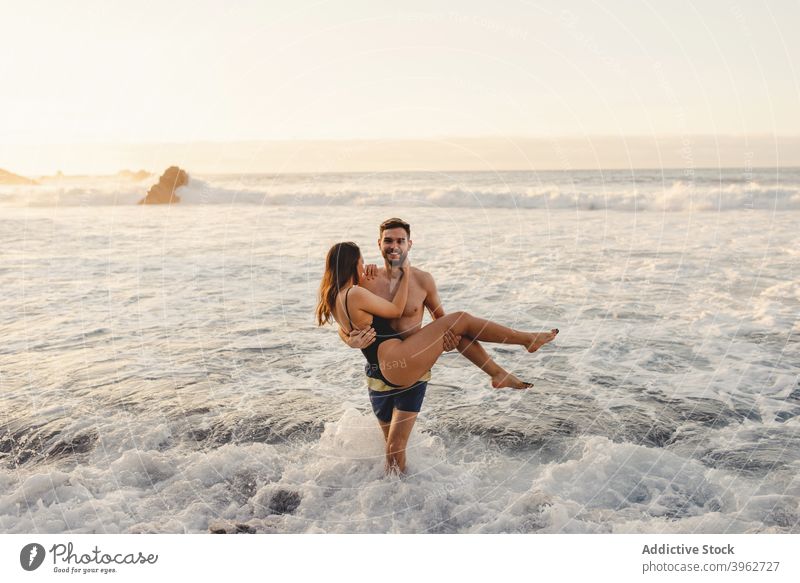 Glückliches Paar mit Spaß in schaumigen Meer Wellen MEER winken romantisch Liebe Spaß haben Strand Zusammensein Sonnenuntergang Wasser Zuneigung jung Teneriffa