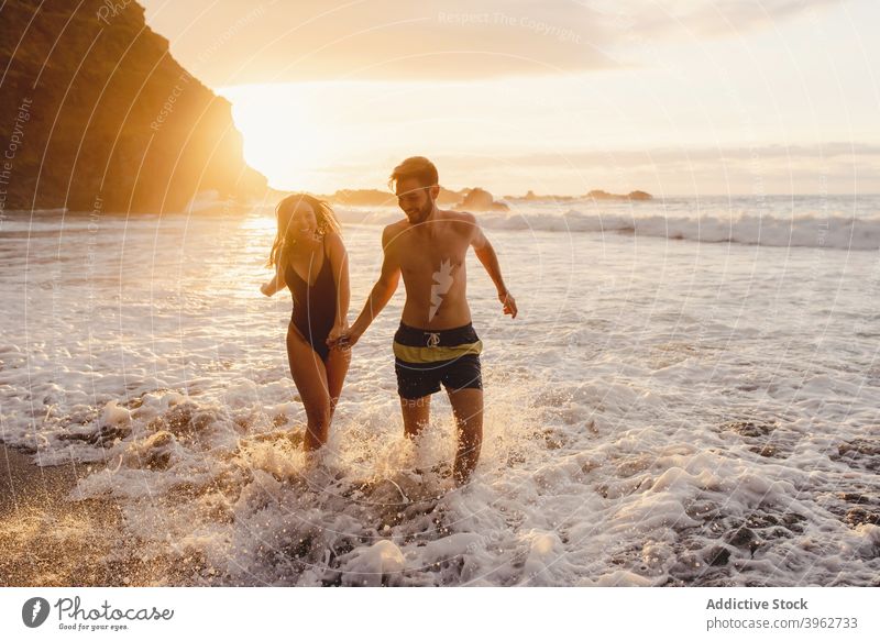 Romantisches Paar zu Fuß auf schäumenden Meer Wellen MEER Sonnenuntergang winken romantisch Liebe Strand Zusammensein Glück Spaß haben Händchenhalten Küste