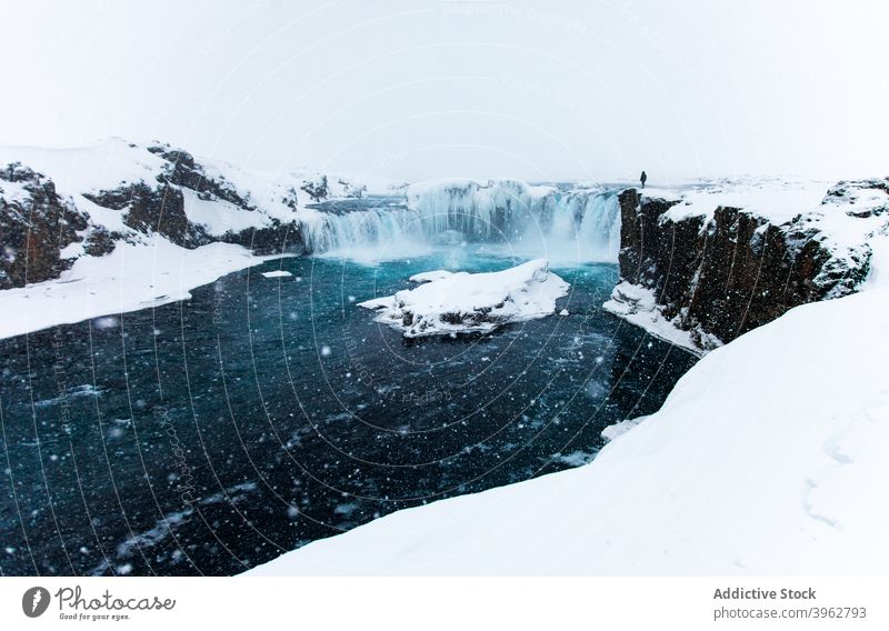 Reisende auf Felsen in der Nähe von Wasserfall im Winter Reisender Klippe Schnee atemberaubend Landschaft beobachten Aussichtspunkt Island Entdecker Saum