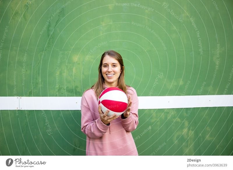 junge langhaarige Frau hält einen Basketball gegen grüne Wand Sport Person Fitness Training Athlet Ball Beteiligung Mädchen Spieler Übung Gesundheit Lifestyle