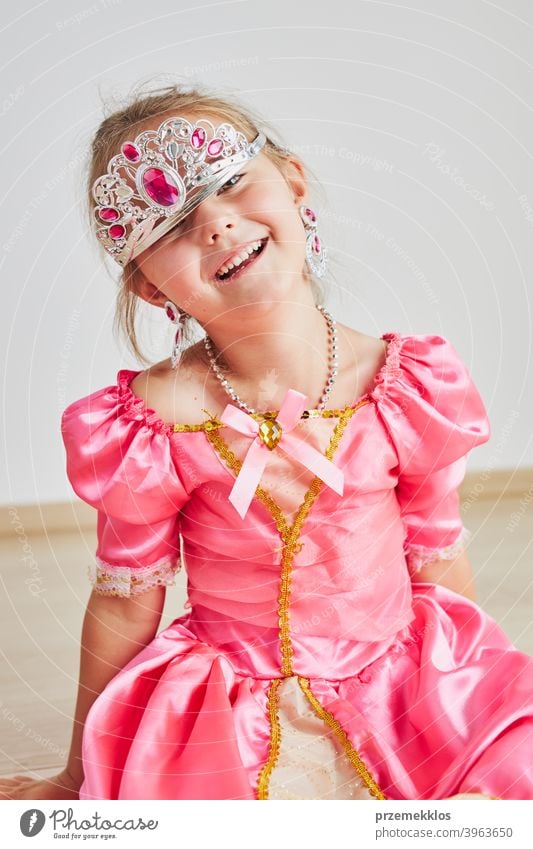 Kleines Mädchen genießt ihre Rolle der Prinzessin. Adorable niedlichen 5-6 Jahre altes Mädchen trägt rosa Prinzessin Kleid und Tiara Fee Kind Stadtfest