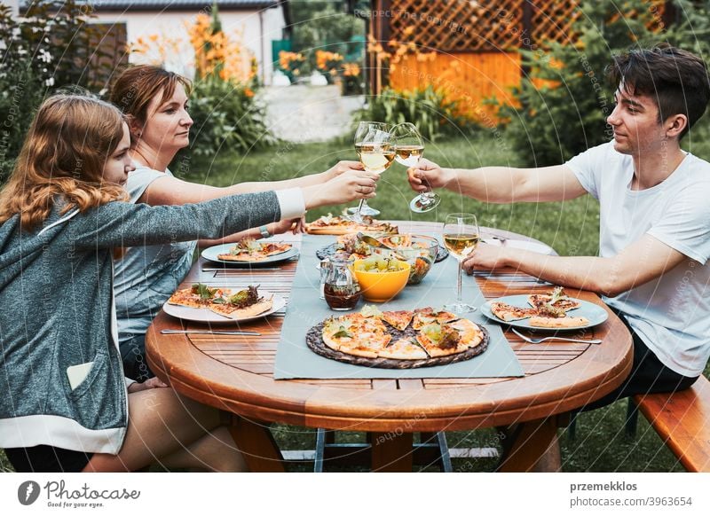 Freunde machen Toast während Sommer-Picknick im Freien Abendessen in einem Haus Garten Hinterhof Getränk Feier Speise trinken Essen Familie Festessen