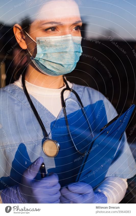 Arzt schaut durch das Fenster blau Pflege Klinik Korona Coronavirus COVID Krankheit Notfall Seuche erschöpft Gesicht Angst Frau Frontlinie Frustration Glas