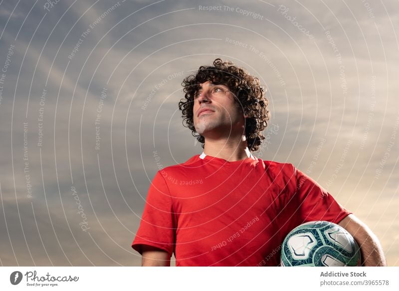 Fußballspieler beim Ausruhen auf dem Sportplatz Spieler besinnlich Feld Sportler nachdenklich Ball Stadion Sportpark Mann ernst Bestimmen Sie Dämmerung