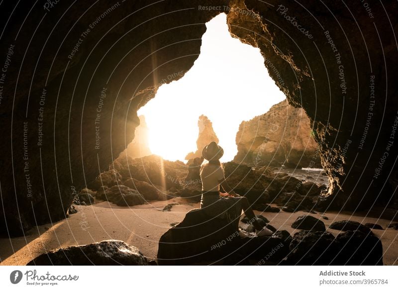 Unerkennbare Frau bewundert Höhle in der Nähe von Meer MEER bewundern Urlaub sonnig tagsüber reisen Algarve Portugal Hut lässig idyllisch Felsen Stein Tourismus