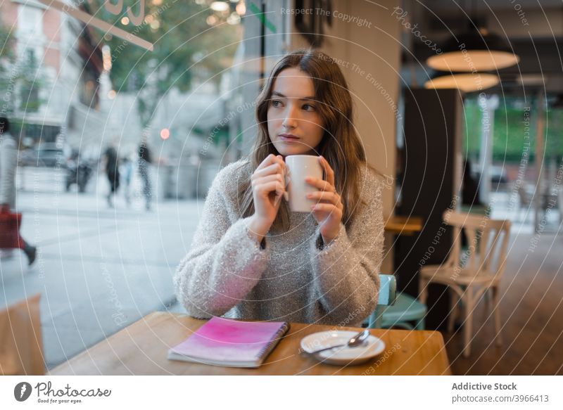 Ruhige Frau beim Chillen im Café am Wochenende Kälte Kaffee Tasse ruhig verträumt nachdenklich sich[Akk] entspannen Tisch Getränk trinken ruhen Heißgetränk jung