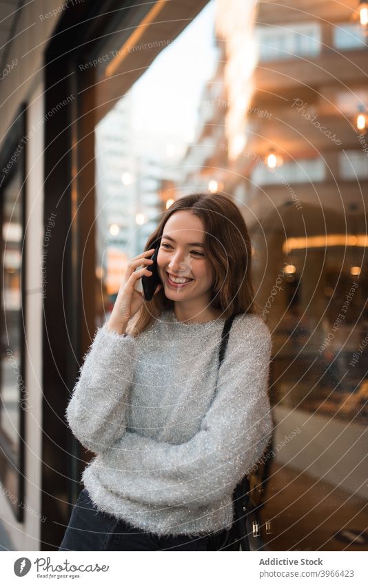 Frau spricht mit Smartphone in der Stadt sprechen Großstadt heiter Lächeln Straße diskutieren Gespräch reden Mobile Telefon Anruf Talkrunde Telefonanruf