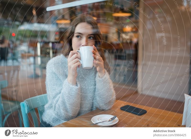 Frau trinkt Kaffee im Café trinken verträumt nachdenklich Fenster Kantine Getränk genießen lecker geschmackvoll sitzen Tisch ruhig Gelassenheit Tasse gemütlich