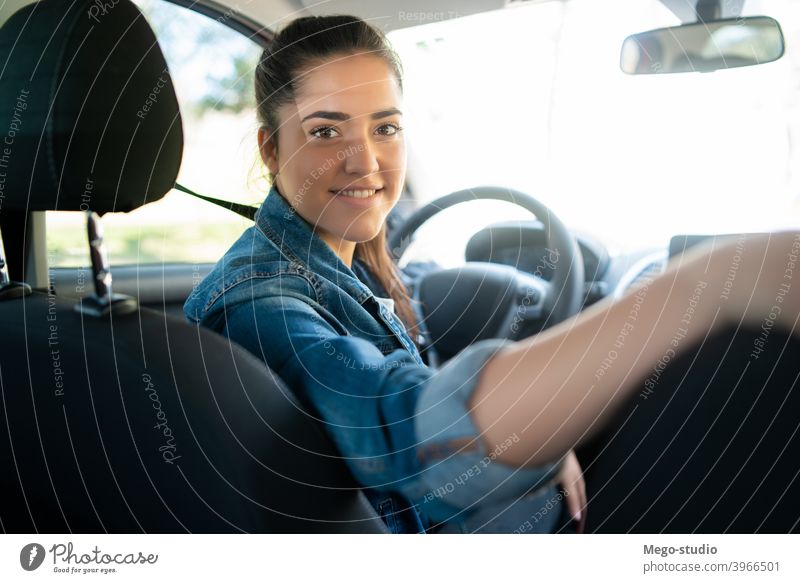 Frau fährt ihr Auto und schaut auf den Rücksitz jung PKW Business Geschäftsmann Kabine professionell reisen Großstadt Transport Taxi fahren urban Dienst