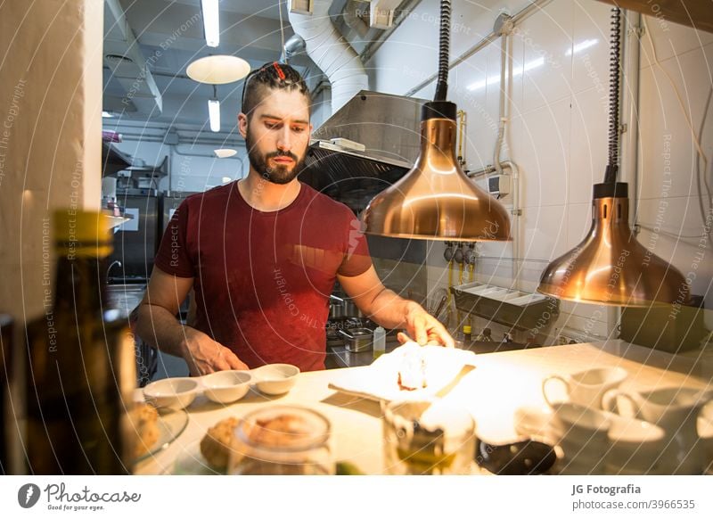 Koch bei der Arbeit in der Küche. Dienst rotes Fleisch Essen und Trinken engagiert jung Beschichtung wirtschaftlich Kochen stylen Catering 2 Küchenchef Ordnung