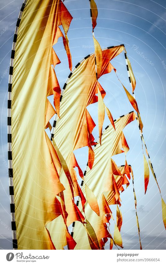 Beachflag Fahnen wie Feuer Wind Fahnenmast flattern wehen Himmel Außenaufnahme Menschenleer Schönes Wetter gelb rot Wolken Blauer Himmel wehende fahnen Flagge