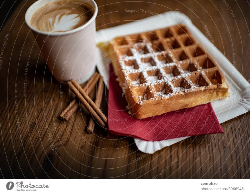 Belgische Waffeln und Cappuccino take away Süßspeisen Gebäck to go coffee flat white Latte Macchiato Barista Holztisch Zimt Puderzucker Dessert lecker