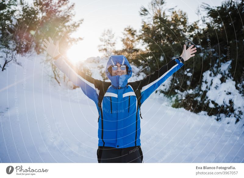 glücklich gut aussehend Mann in verschneiten Berg bei Sonnenuntergang. Reisen und Sport im Freien Konzept. Wintersaison Schnee Berge u. Gebirge wandern kalt