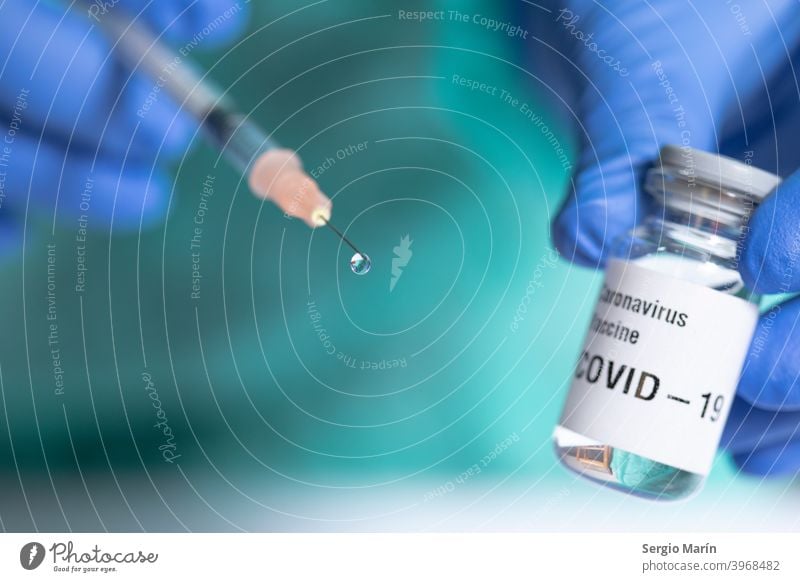 Nahaufnahme der Spritze mit einem Impftropfen. Fokus auf den Tropfen. Coronavirus COVID Korona 19 Virus Behandlung Kur Medikament Einspritzung Schuss Therapie