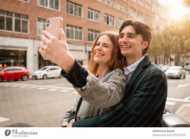 Verliebtes junges Paar nimmt Selfie auf der Straße Liebe Zusammensein Glück Smartphone Partnerschaft Umarmen Freundin heiter Lifestyle romantisch Zuneigung