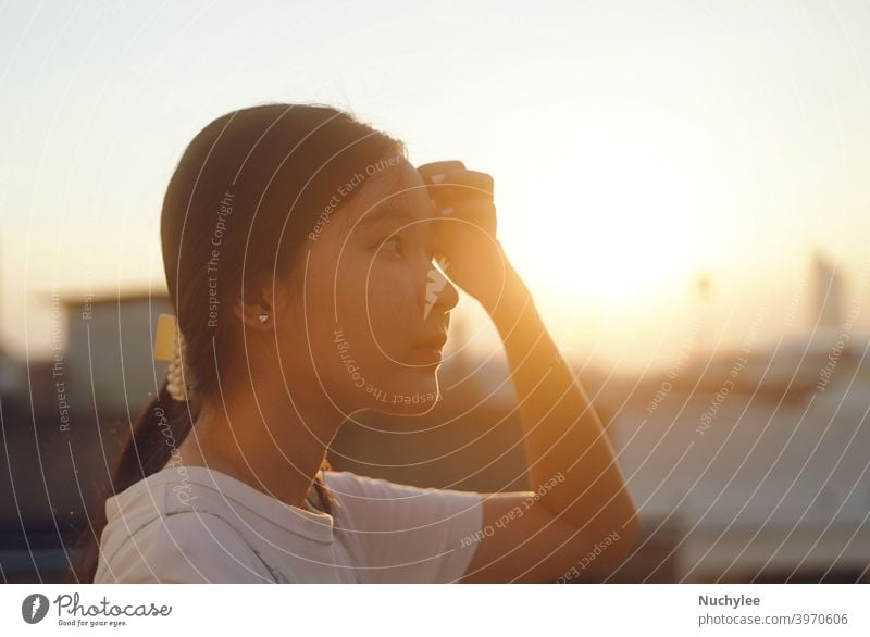 Junge asiatische Millennial Teenager-Mädchen mit Blick auf den Sonnenuntergang Himmel, emotionales Gefühl, ruhig und friedlich Hintergrund allein attraktiv