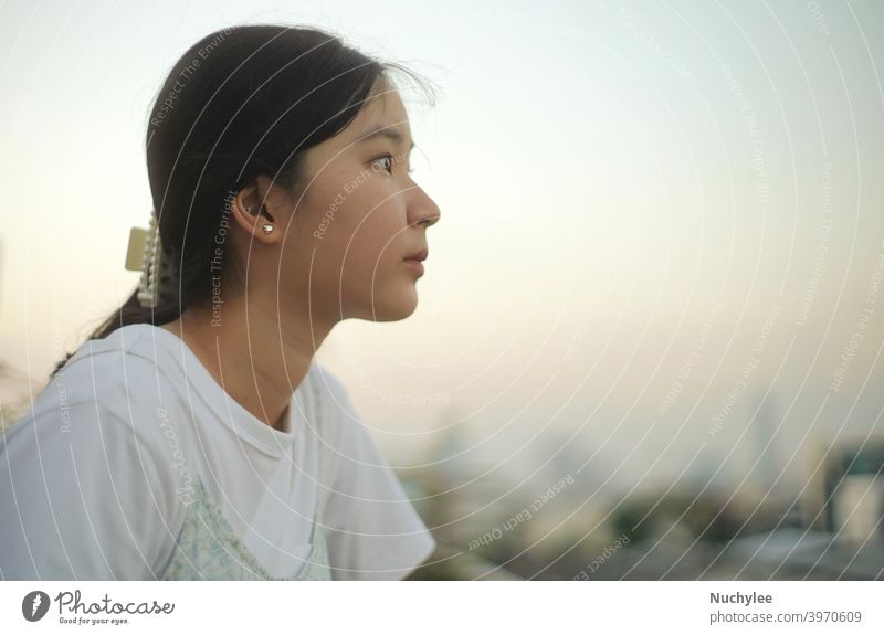 Junge asiatische Millennial Teenager-Mädchen mit Blick auf den Sonnenuntergang Himmel, emotionales Gefühl, ruhig und friedlich Hintergrund allein attraktiv