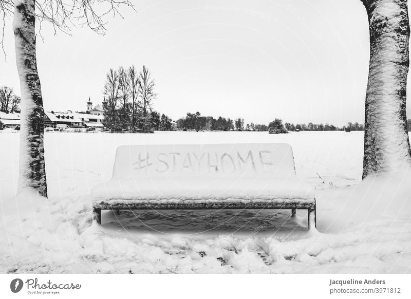 Bank im Schnee mit Hashtag Stay home stayhome Bleibt zuhause Bleibt daheim stay home Schrift Landschaft Bäume stay at home zuhause bleiben Quarantäne Schützen