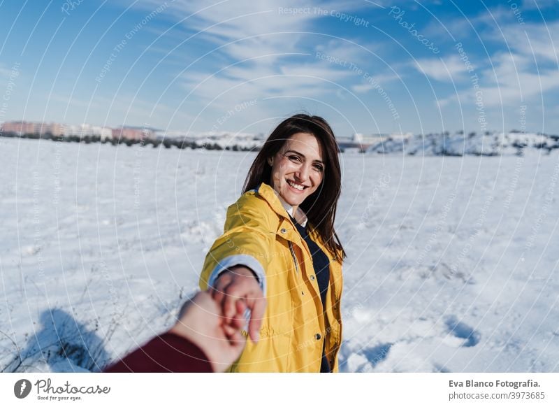 glückliche junge Frau hält Hände mit Kamera. Schnee Berglandschaft. Folgen Sie mir. Liebe und Lebensstil in der Natur Berge u. Gebirge Beteiligung Freund