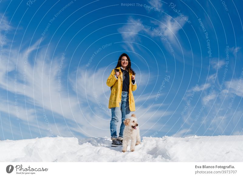 Backpacker Frau Wandern im Freien mit niedlichen Pudel Hund. Snowy Berg in der Wintersaison. Natur, Haustiere und Lebensstil Rucksack Berge u. Gebirge Schnee