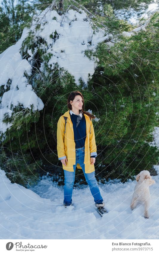 Backpacker Frau Wandern im Freien mit niedlichen Pudel Hund. Snowy Berg in der Wintersaison. Natur, Haustiere und Lebensstil Rucksack Berge u. Gebirge Schnee