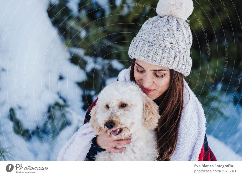 schöne Frau in verschneiten Berg Holding niedlichen Pudel Hund in den Armen in karierten Decke gewickelt. Wintersaison. Natur und Haustiere Schnee