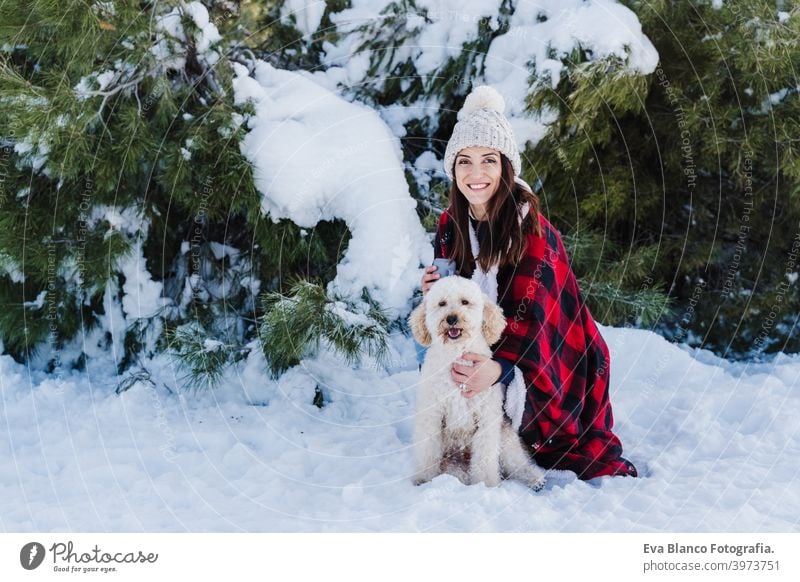 schöne Frau in verschneiten Berg Holding niedlichen Pudel Hund in den Armen in karierten Decke gewickelt. Wintersaison. Natur und Haustiere Schnee