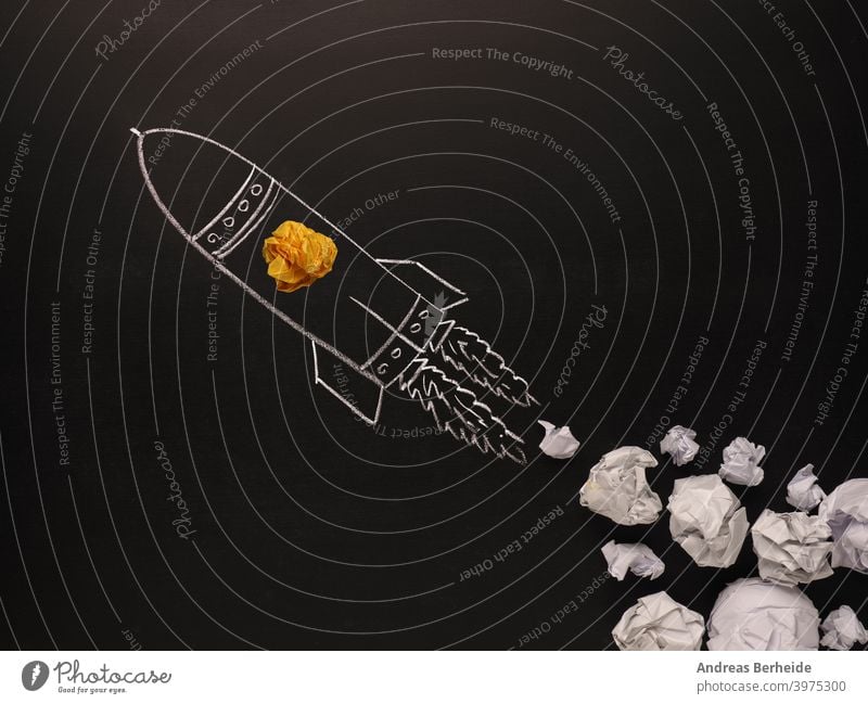 Startende Rakete mit Jet-Stream von Papierkugeln, Kreativität Konzept oder neue Ideen Metapher, Start-up-Geschäft Licht Knolle schwarz Tafel Holzplatte hell