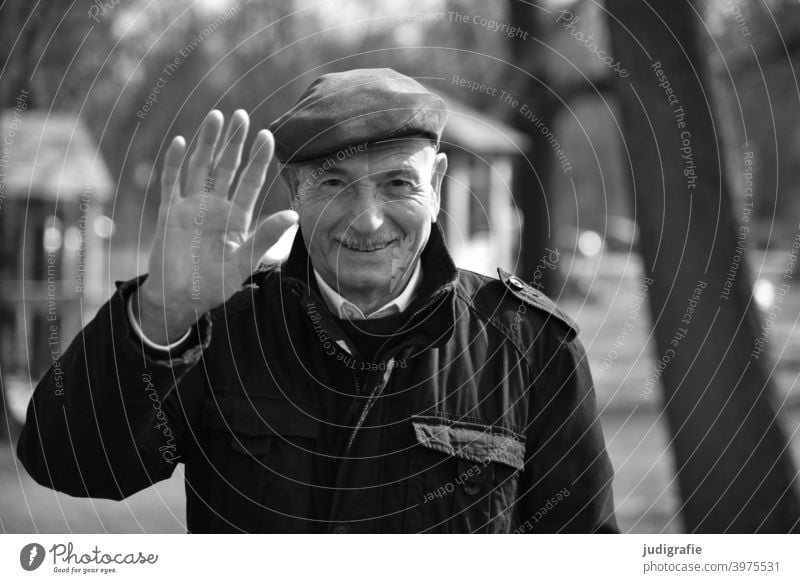 Senior winkt freundlich in die Kamera Mann winken Freundlichkeit nett Männlicher Senior Mensch maskulin Großvater Leben Blick Erwachsene Blick in die Kamera