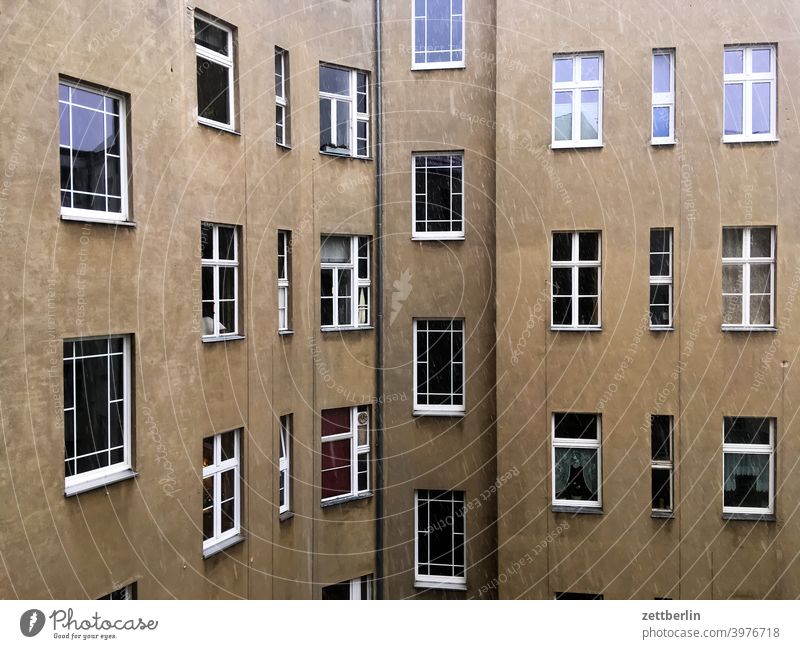 Hinterhof in Schöneberg mit leichtem Schneefall altbau außen brandmauer fassade fenster haus himmelblau hinterhaus hinterhof innenhof innenstadt