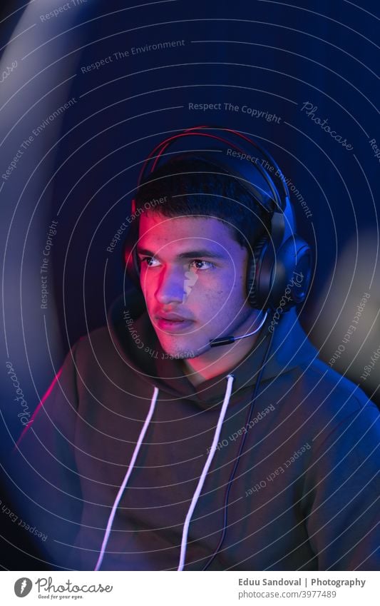 Junger Mann, der ein Live-Videospiel online teilt. Raum Spielen Menschen Cyberspace Entertainment Keyboard Kopfhörer jung Technik & Technologie Spaß Headset