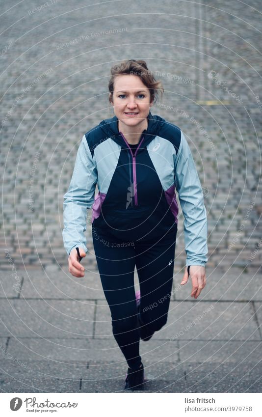 FRAU - SPORTLICH - TREPPENAUFSTIEG Frau 30 Jahre alt Zopf trainingsjacke Trainingshose Fitness Treppenstufen Erwachsene Farbfoto sportlich Sport Sportbekleidung