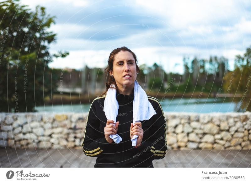 Müde sportliche Frau mit Handtuch entspannt nach hartem Training im Park. passen Mädchen Gesundheit Lifestyle Video Wellness Aerobic allein Gleichgewichtskörper