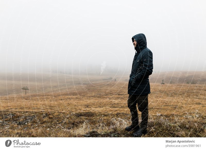 Junger Mann erkundet die Natur an einem nassen Wintermorgen in den Bergen Abenteuer allein Herbst schön Herausforderung kalt Europa Erkundung erkunden Entdecker