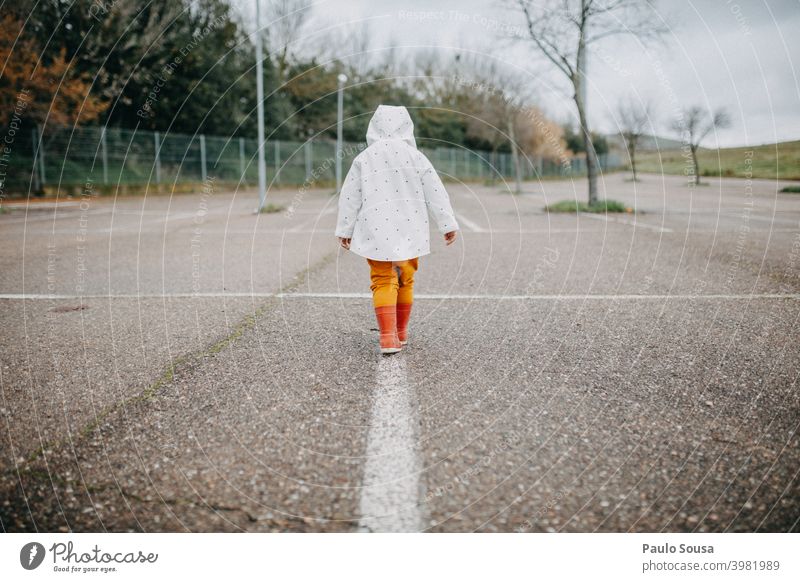 Rückansicht Kind gehend mit roten Gummistiefeln Mädchen 1-3 Jahre Kaukasier Stiefel Tag Spielen Außenaufnahme Kindheit Mensch Farbfoto Kleinkind mehrfarbig