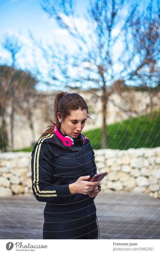 Porträt einer sportlichen jungen Frau mit Kopfhörern, während sie im Freien trainiert. heiter Musik Menschen Sport Erwachsener attraktiv Hintergrund schön blond